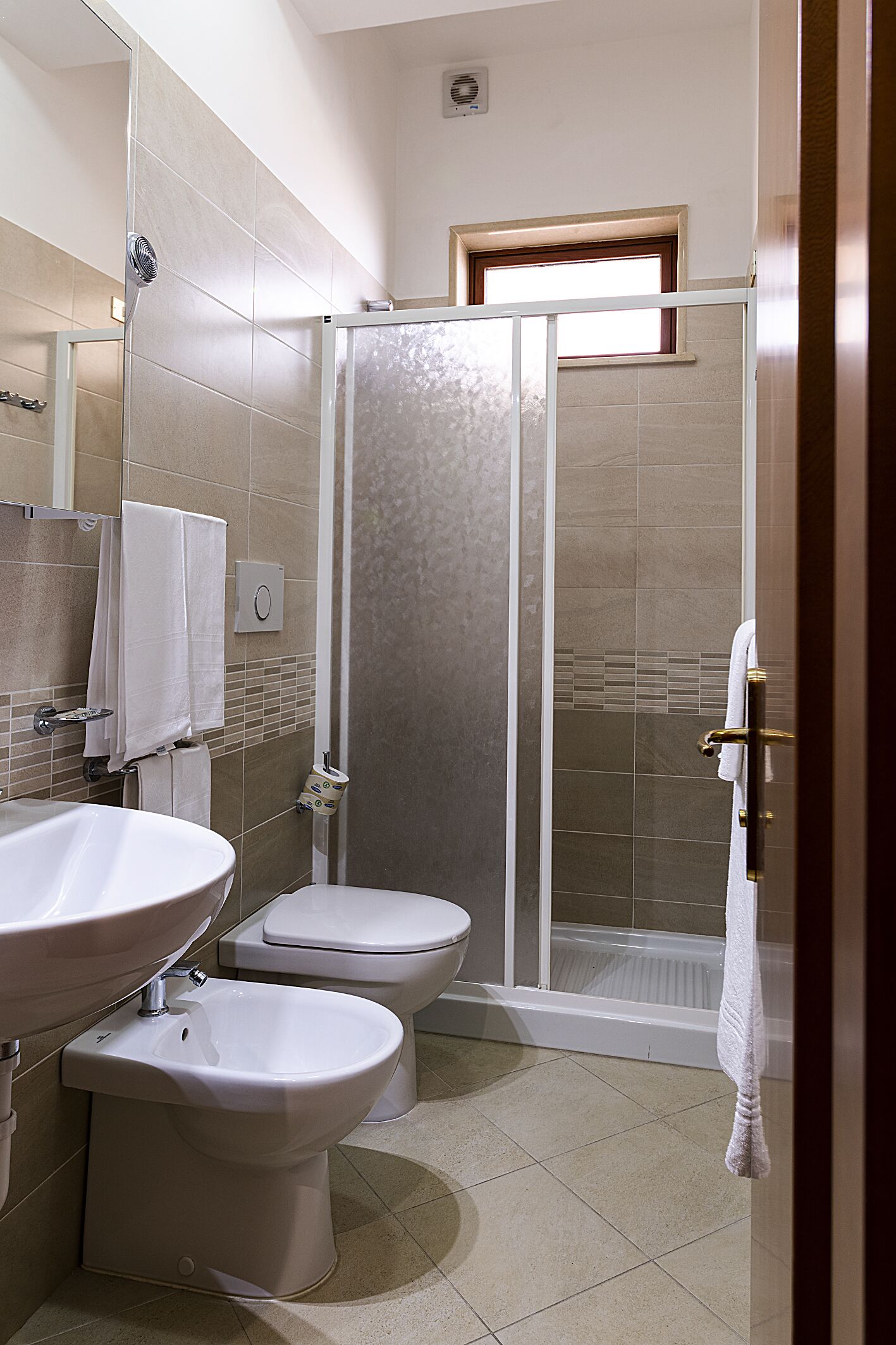 Ein Badezimmer mit Dusche, Toilette und Waschbecken.