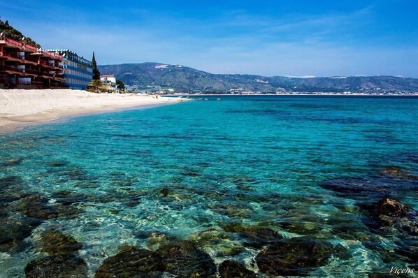 Playa en los alrededores, playa de arena blanca, camastros y sombrillas
