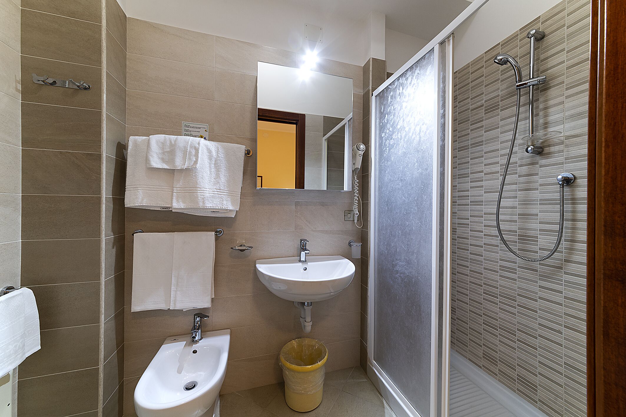 A bathroom with a sink, mirror, and shower.