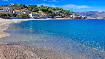 Una spiaggia nelle vicinanze, sabbia bianca, lettini da mare, ombrelloni