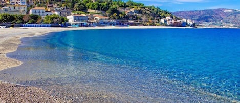 Una spiaggia nelle vicinanze, sabbia bianca, lettini da mare, ombrelloni