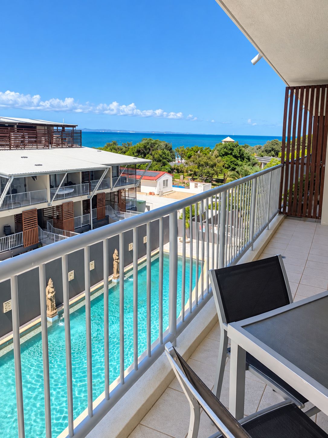 Varanda com vista para uma piscina e o oceano.