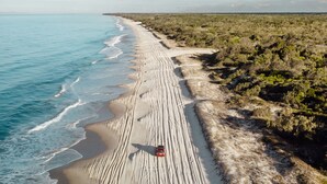 A beach with a vehicle on the sand. - On the Beach Resort Bribie Island (Woorim)