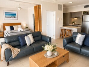 Una sala moderna con sofá, mesa de centro y cama con vistas.