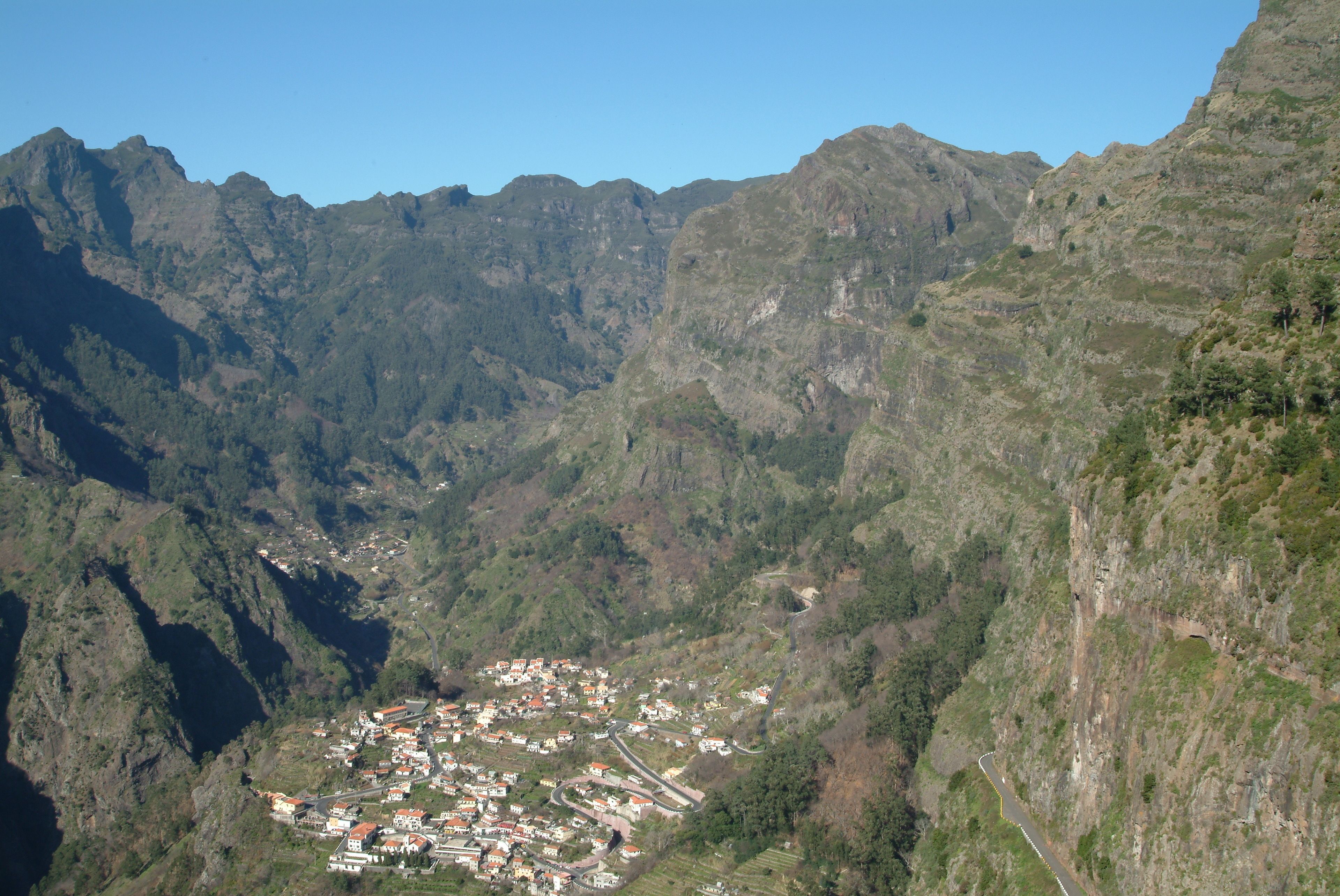 Un paisaje montañoso con un pequeño pueblo situado en un valle.