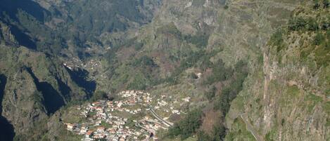 Un paisaje montañoso con un pequeño pueblo situado en un valle.