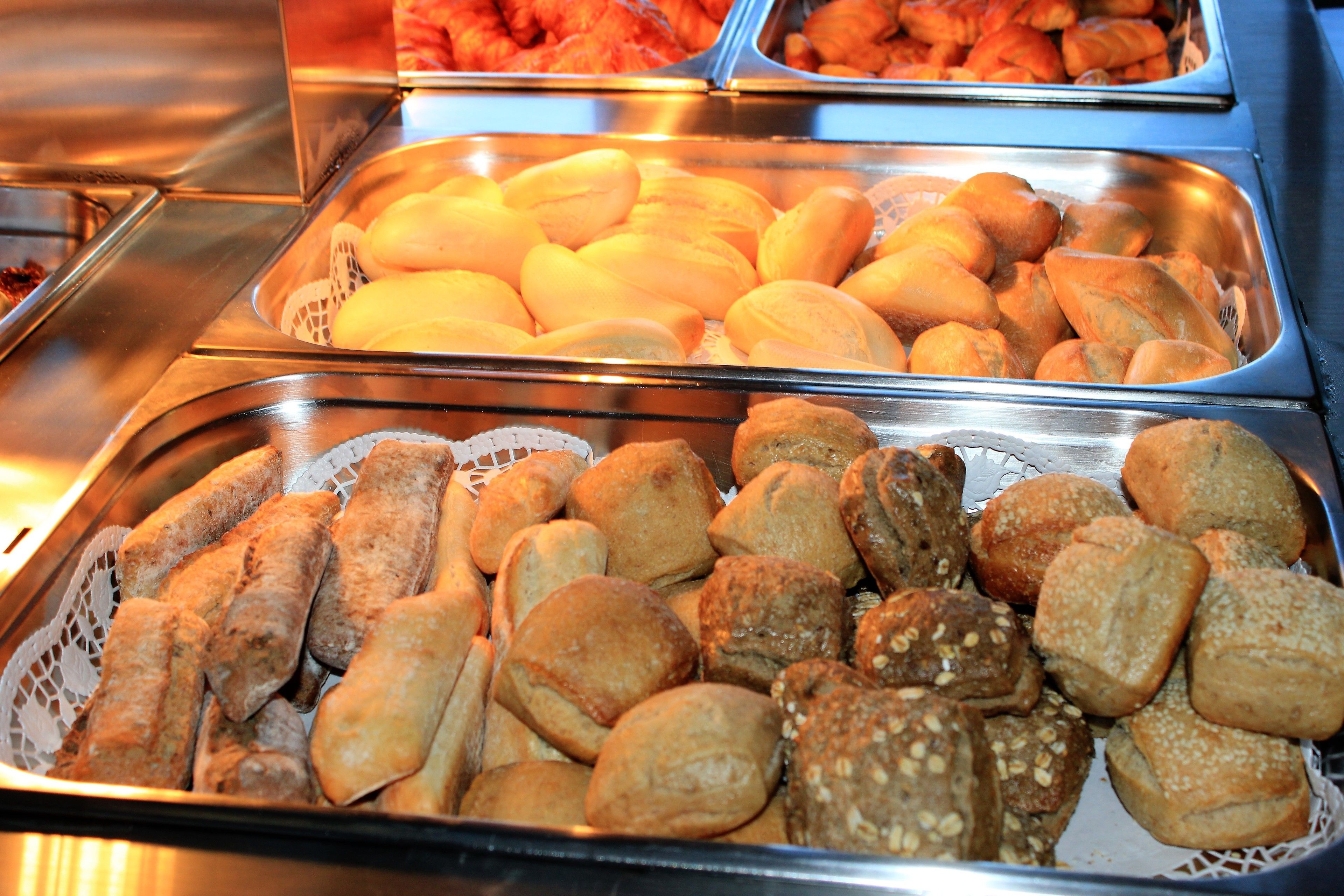 Un buffet proposant une variété de produits de boulangerie, notamment des petits pains et des viennoiseries.