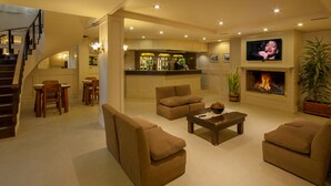 Una sala de estar amplia con sofás, una mesa de centro, una chimenea y una televisión.