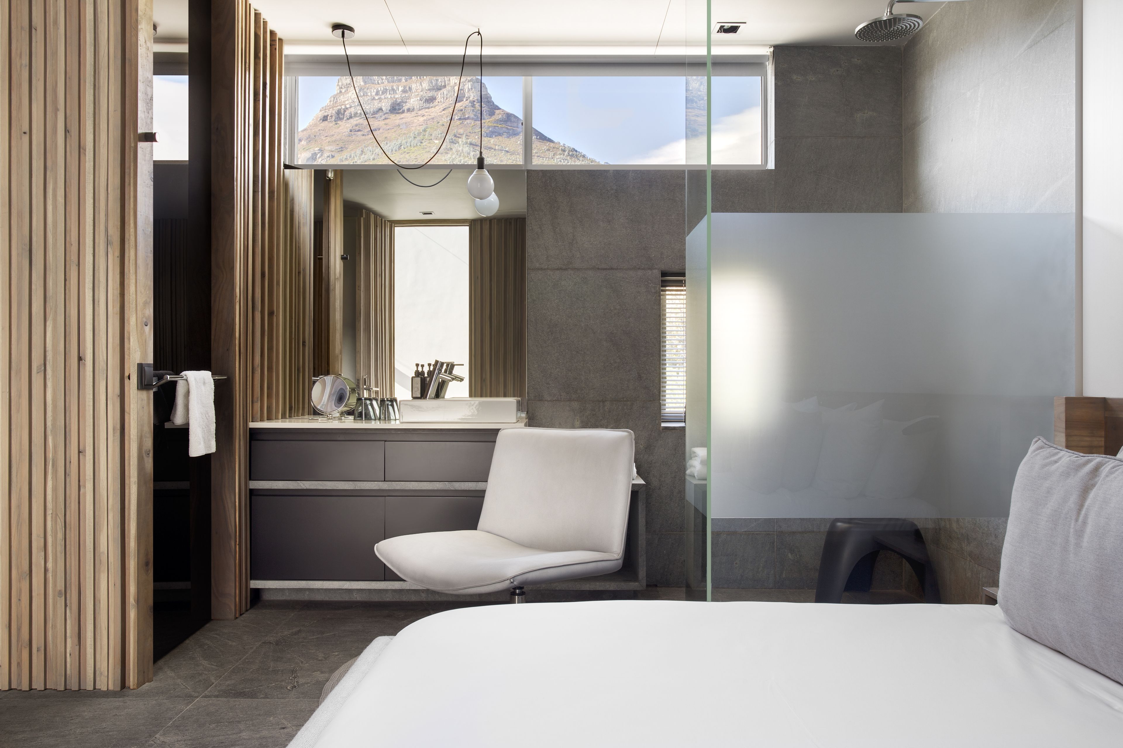 A modern bathroom with a large mirror, a sink, and a shower.