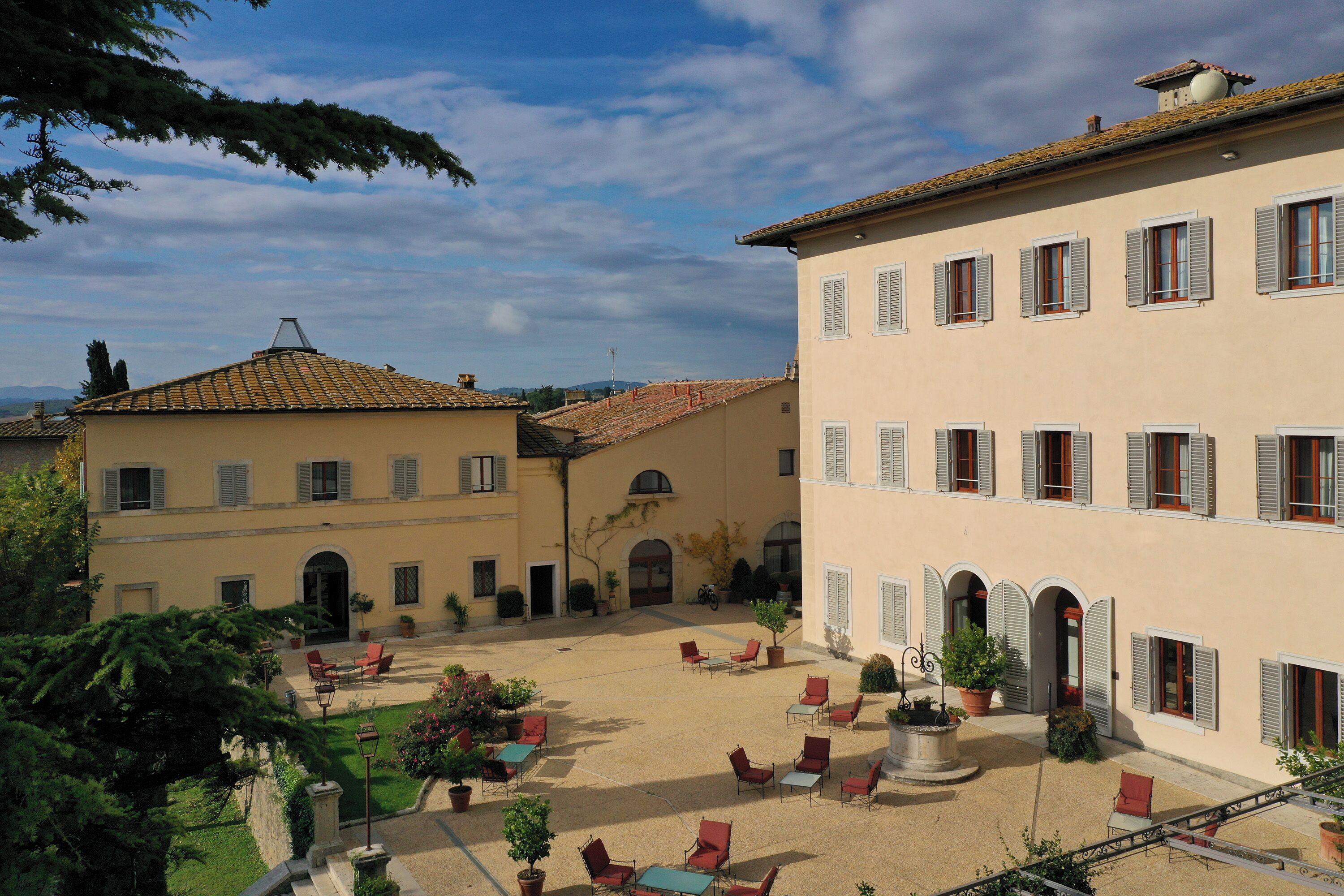 A courtyard with outdoor seating and a building with multiple windows and doors.