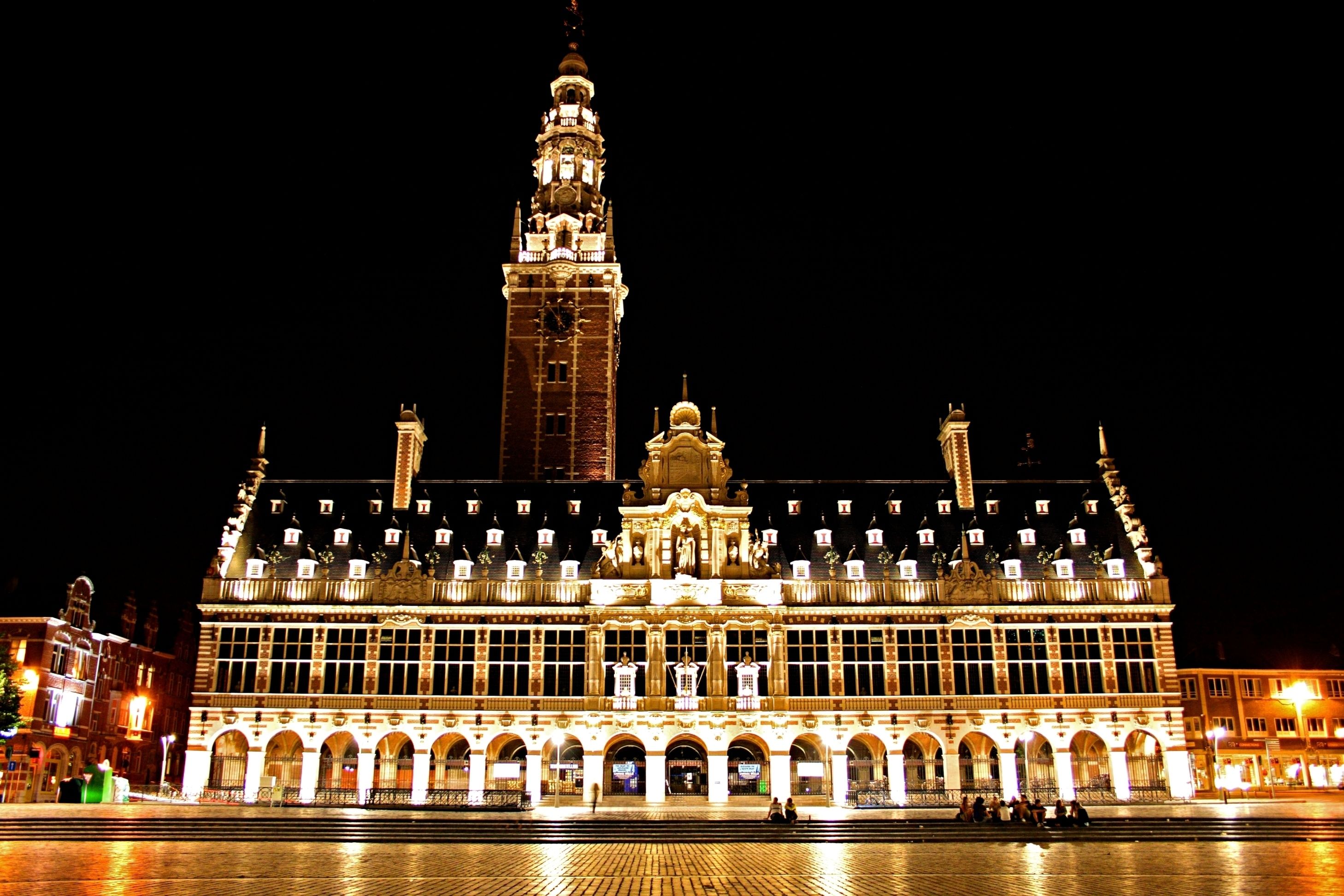 A historic building with a prominent clock tower, large windows, and a symmetrical facade.