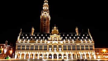 A historic building with a prominent clock tower, large windows, and a symmetrical facade.