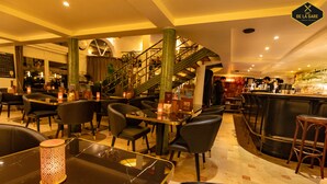 Un restaurant doté d’un bar, de différents espaces pour s’asseoir et d’un escalier menant à un étage supérieur.