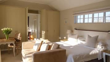 Ein Schlafzimmer mit einem Bett, einem Schreibtisch und einem Stuhl. Es gibt ein Fenster mit Jalousien und ein Bild an der Wand.