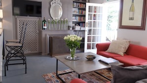 Ein Wohnzimmer mit einem roten Sofa, einem Couchtisch, einem Kamin, einem Bücherregal und einem Fluchtwegschild.