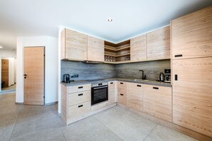 Apartamento superior (OKTETT) | Cocina privada | Frigorífico grande, microondas, placa de cocina y cafetera o tetera