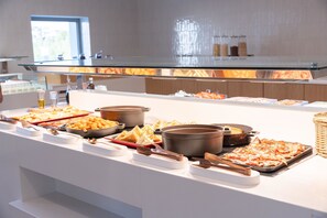 A buffet with various food items and cooking utensils. - Orion Hotel Faliraki (Rhodes)