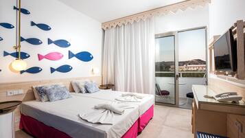 A hotel room with a bed, a desk, a TV, and a balcony with a view.
