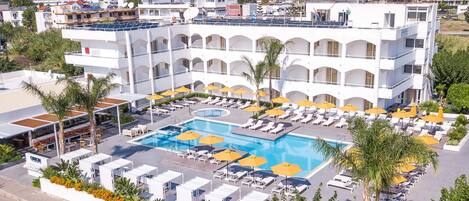 Een buitenzwembad, parasols bij het zwembad en ligstoelen