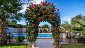 A pool area with a clear view of the pool, surrounded by a well-maintained garden and a decorative archway. - Hotel Tossal d'Altea (Altea)