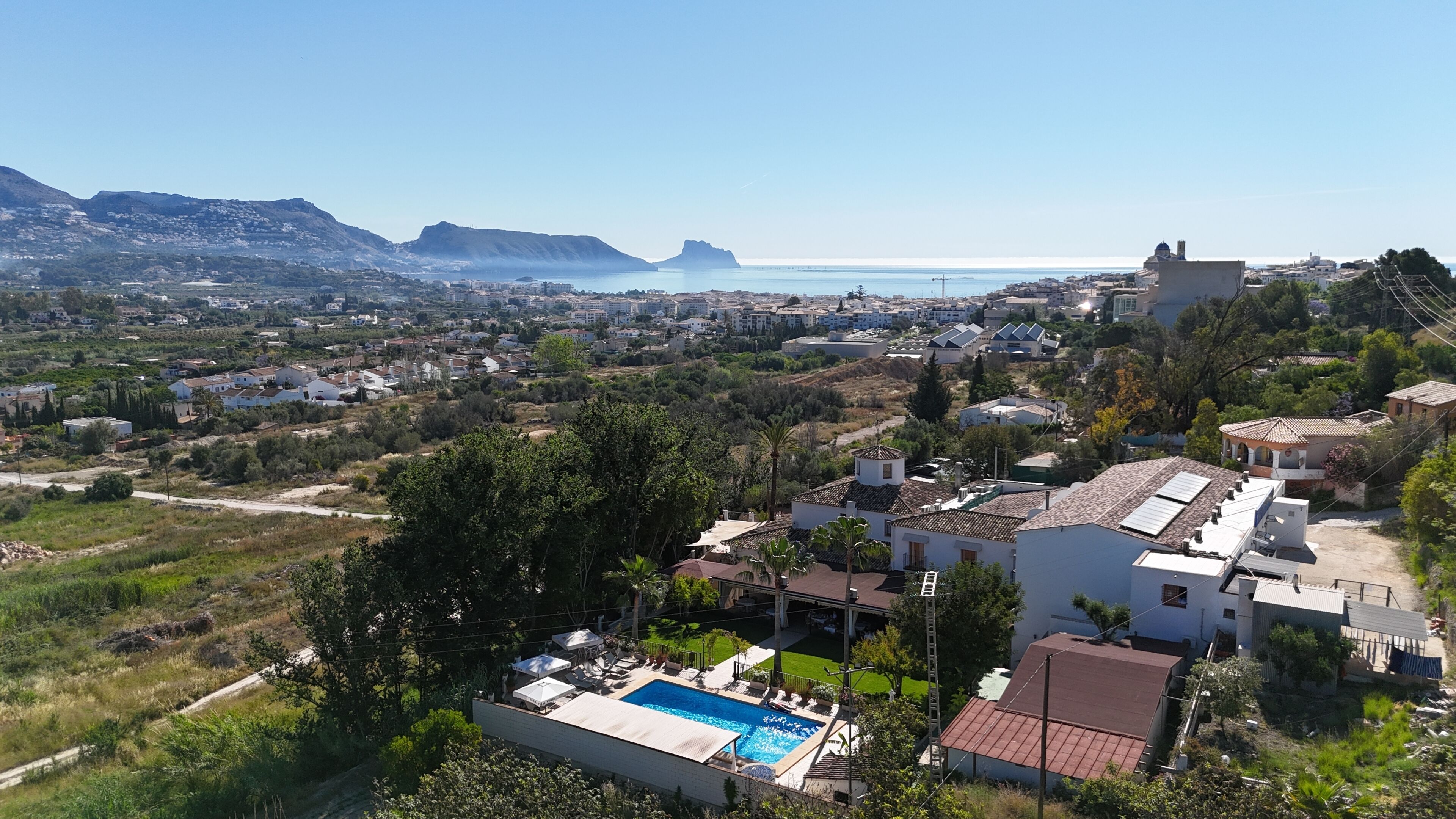 Zona residencial con piscina, casas y vistas al mar.