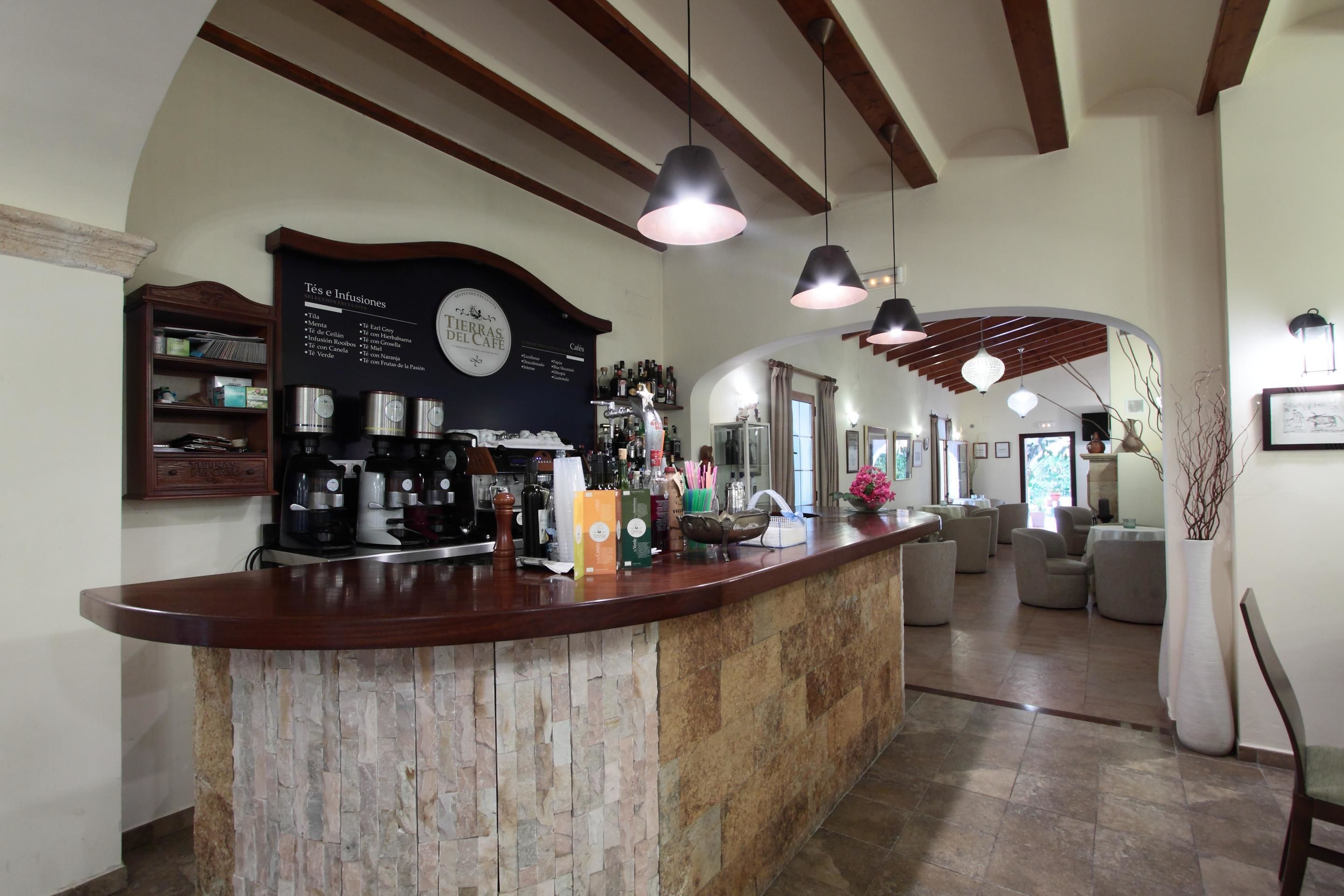 A reception area with a stone counter, coffee machines, and a menu board.