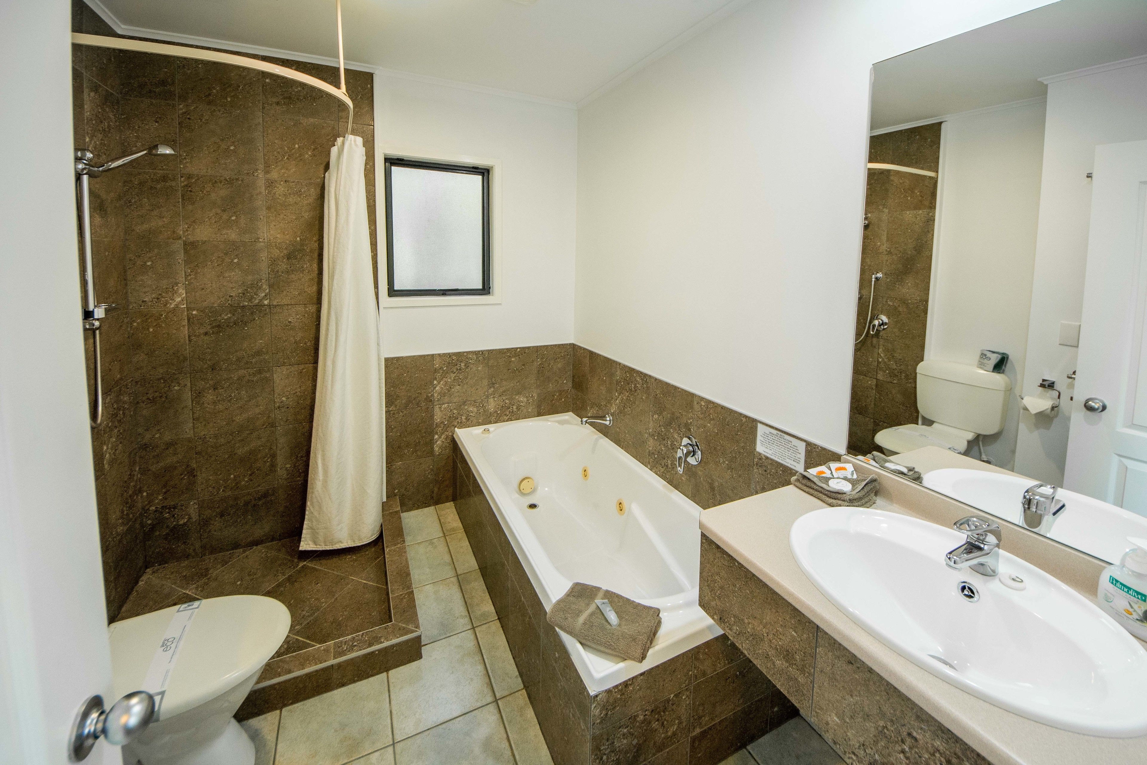A bathroom with a bathtub, a toilet, a sink, and a shower.