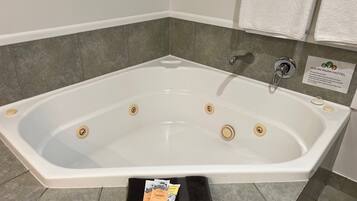 A white bathtub with four drains, a faucet, and a sign for Kauri Park Motel.