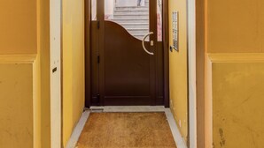 Entrada de hotel con una puerta marrón oscuro, un panel de vidrio arriba y una pieza metálica decorativa con inscripciones.