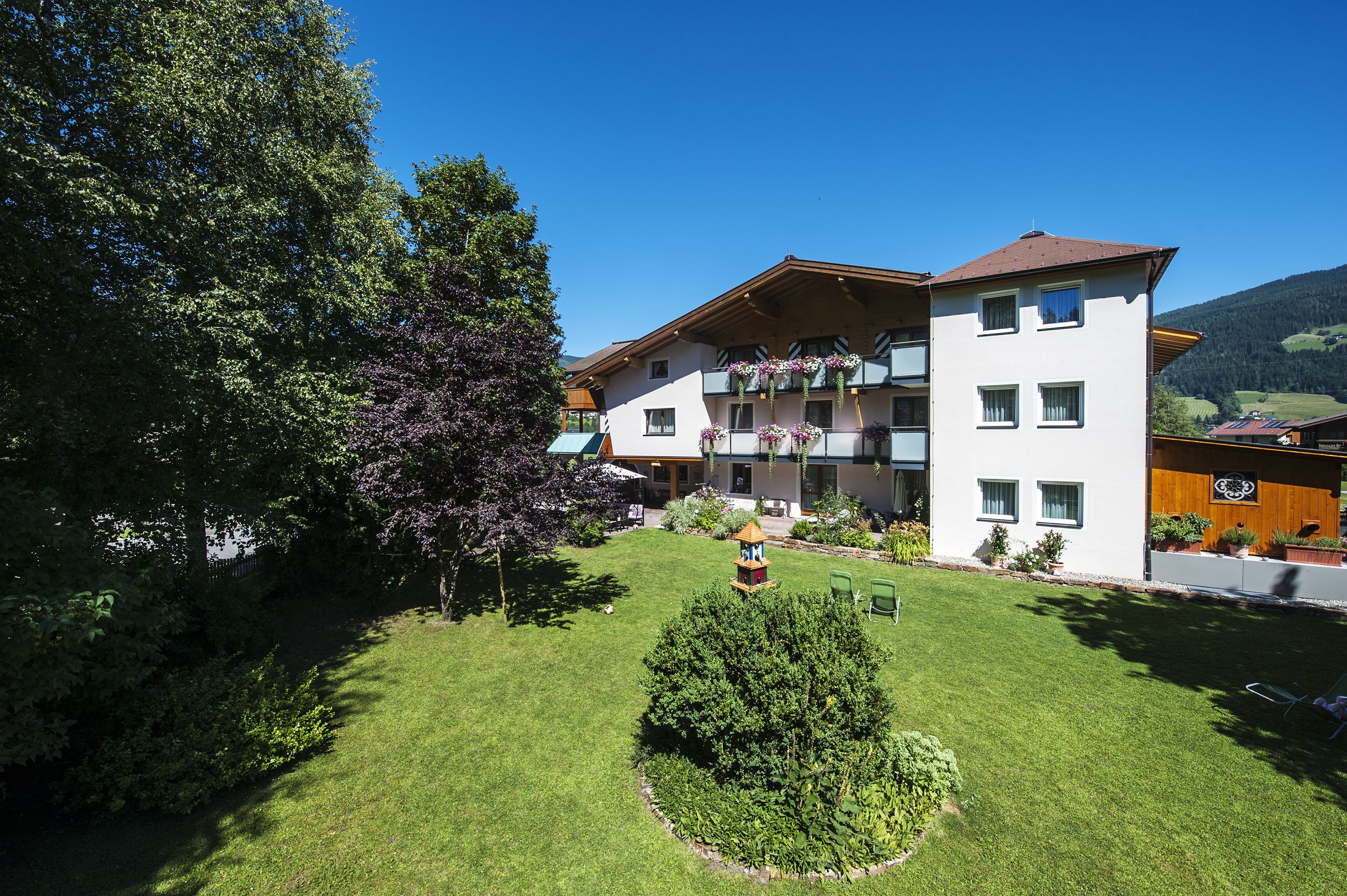 A multi-story hotel with balconies, a well-maintained lawn, and a view of the surrounding landscape.