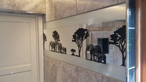 A hallway with a decorative wall featuring silhouettes of elephants and trees. - Solheim Overnatting (Midt-Telemark)