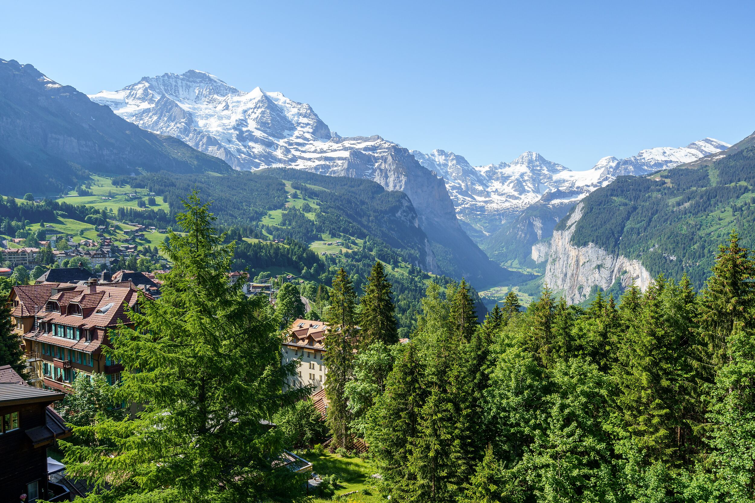 A mountainous landscape with a village and buildings in the foreground.