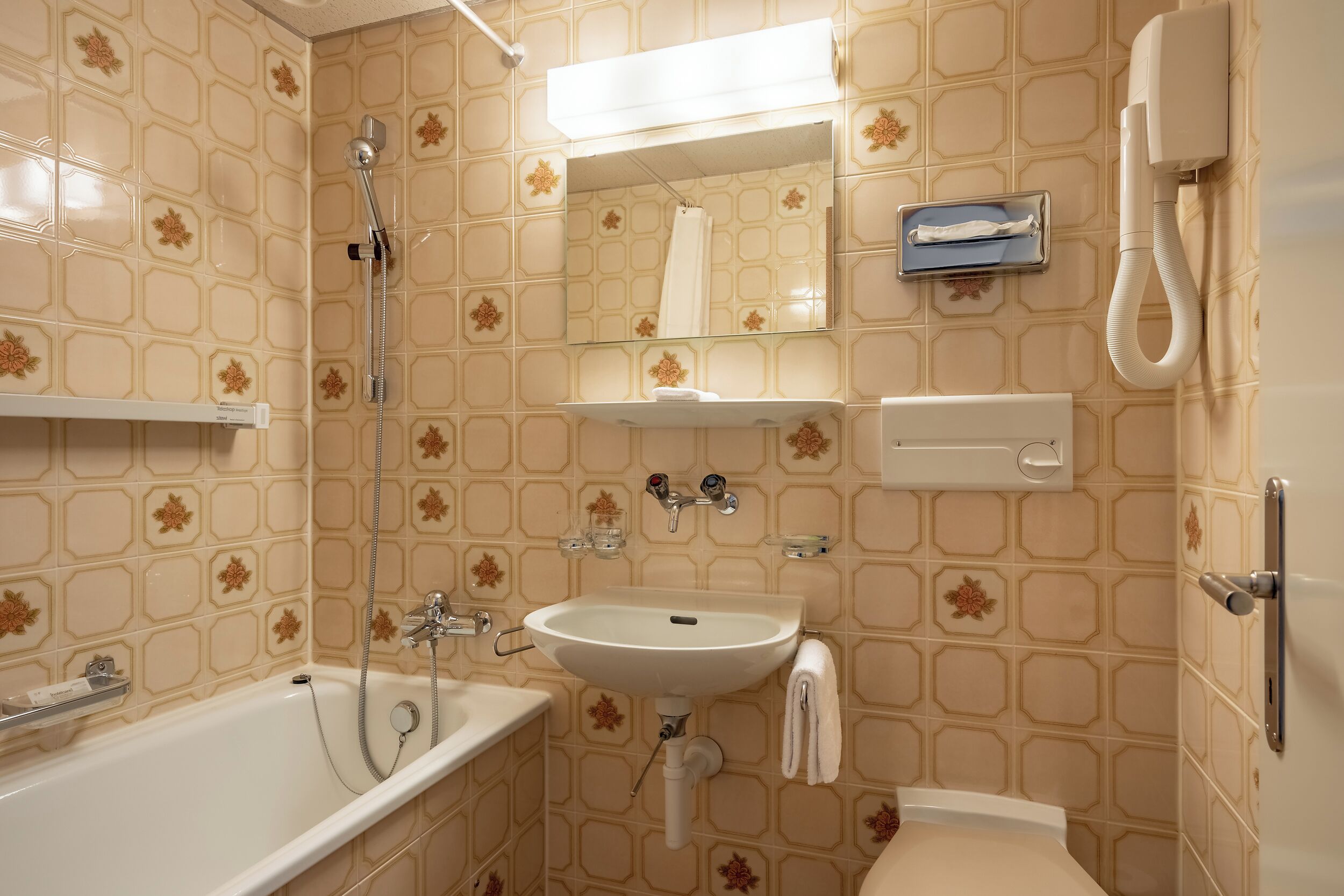 Une salle de bain avec une baignoire, un lavabo, des toilettes et un miroir.