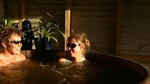 A wooden hot tub with two people. - Beach Hideaway (Barrytown)