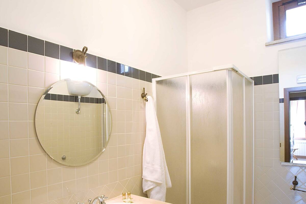 A bathroom with a sink, mirror, and shower.