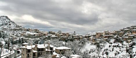 Un pueblo cubierto de nieve con arquitectura tradicional y un camino serpenteante.