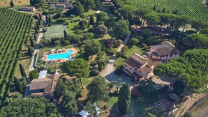 An aerial view of a vineyard estate with terraced fields, a swimming pool, and multiple buildings. - Villa Acquaviva Wine Resort (Manciano)