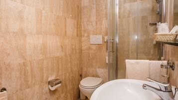 Een moderne badkamer met een douchetoilet, toilet en grote wasbak.