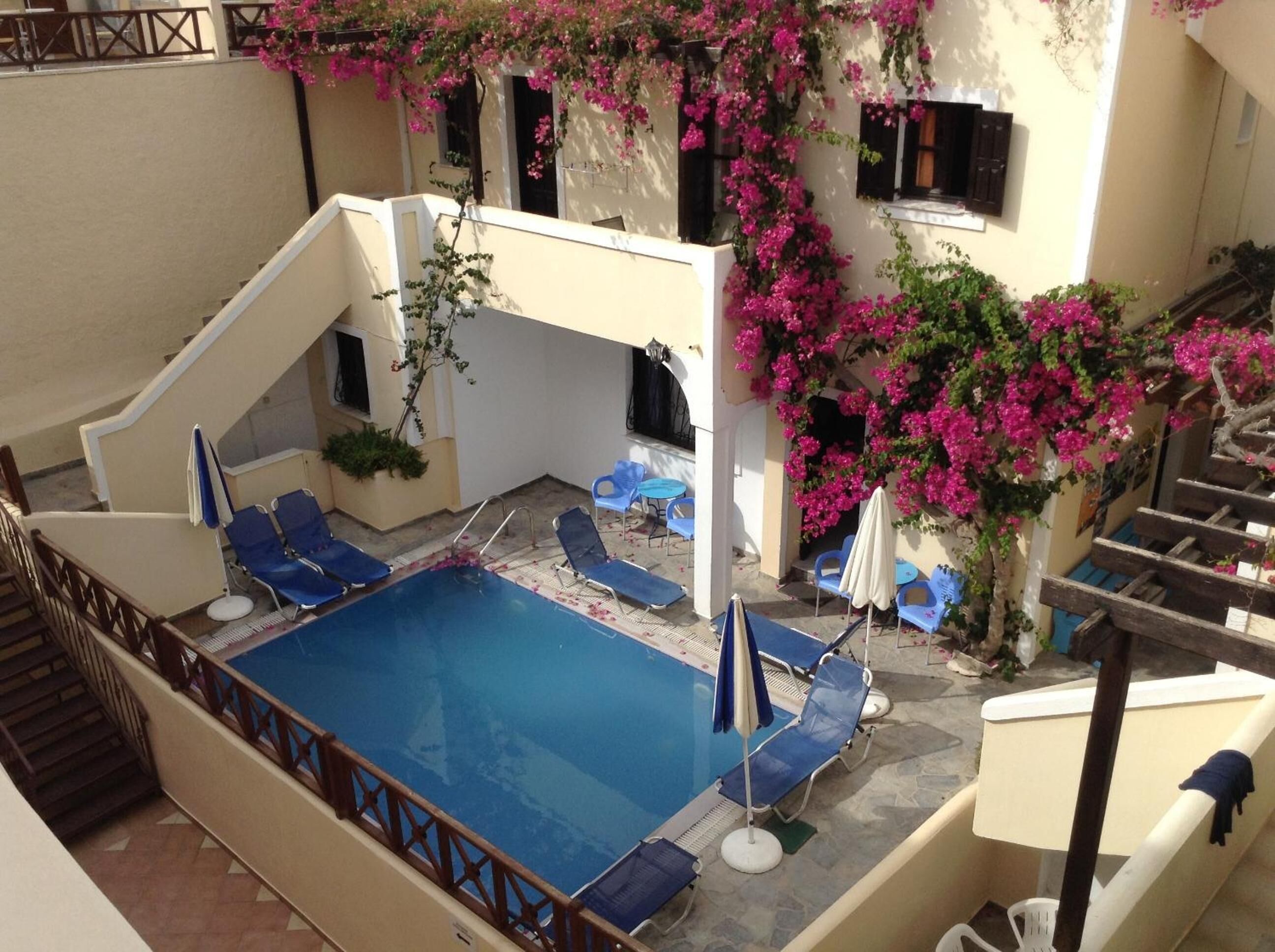 A rooftop pool area with blue lounge chairs and a small pool.