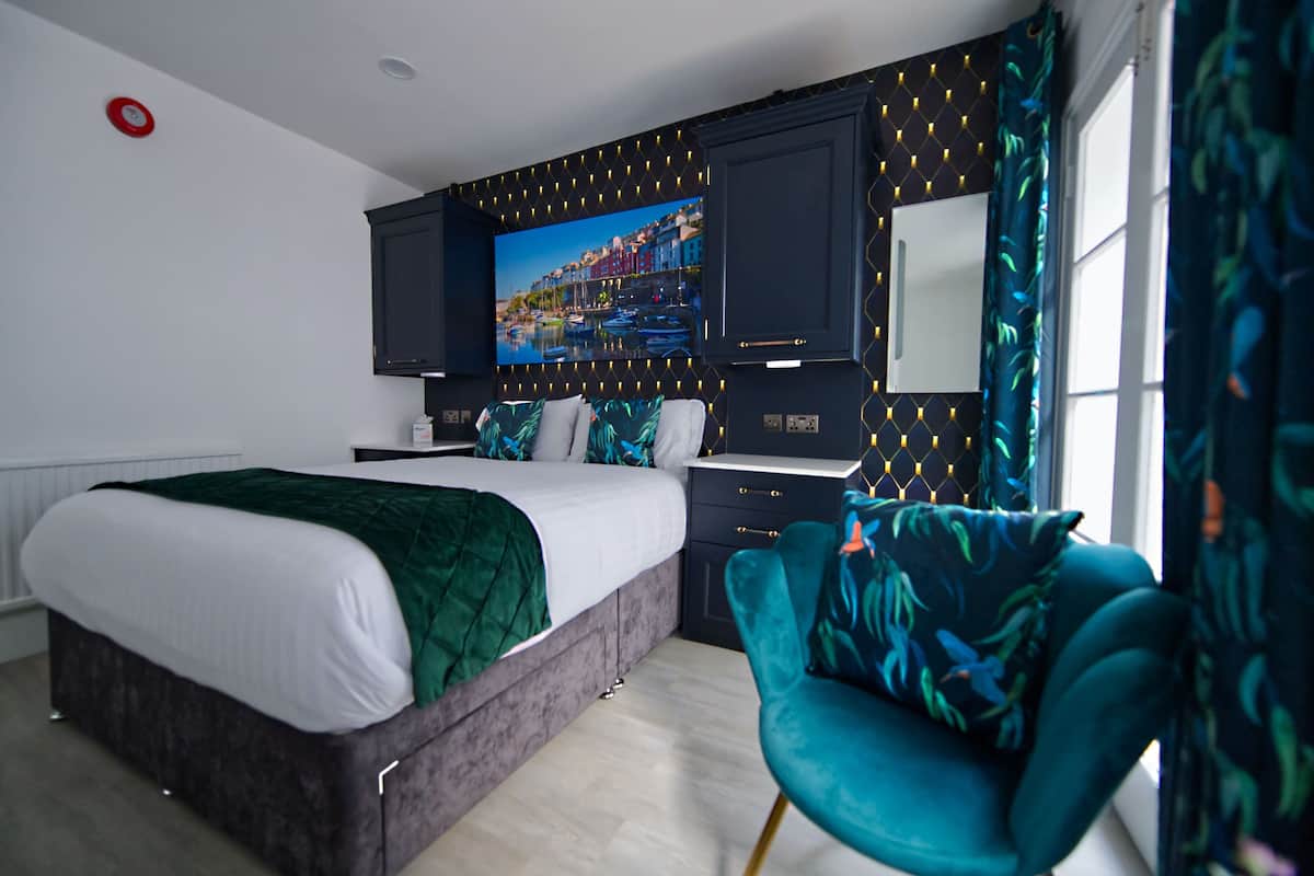 A modern bedroom with a bed, a desk, and a chair.