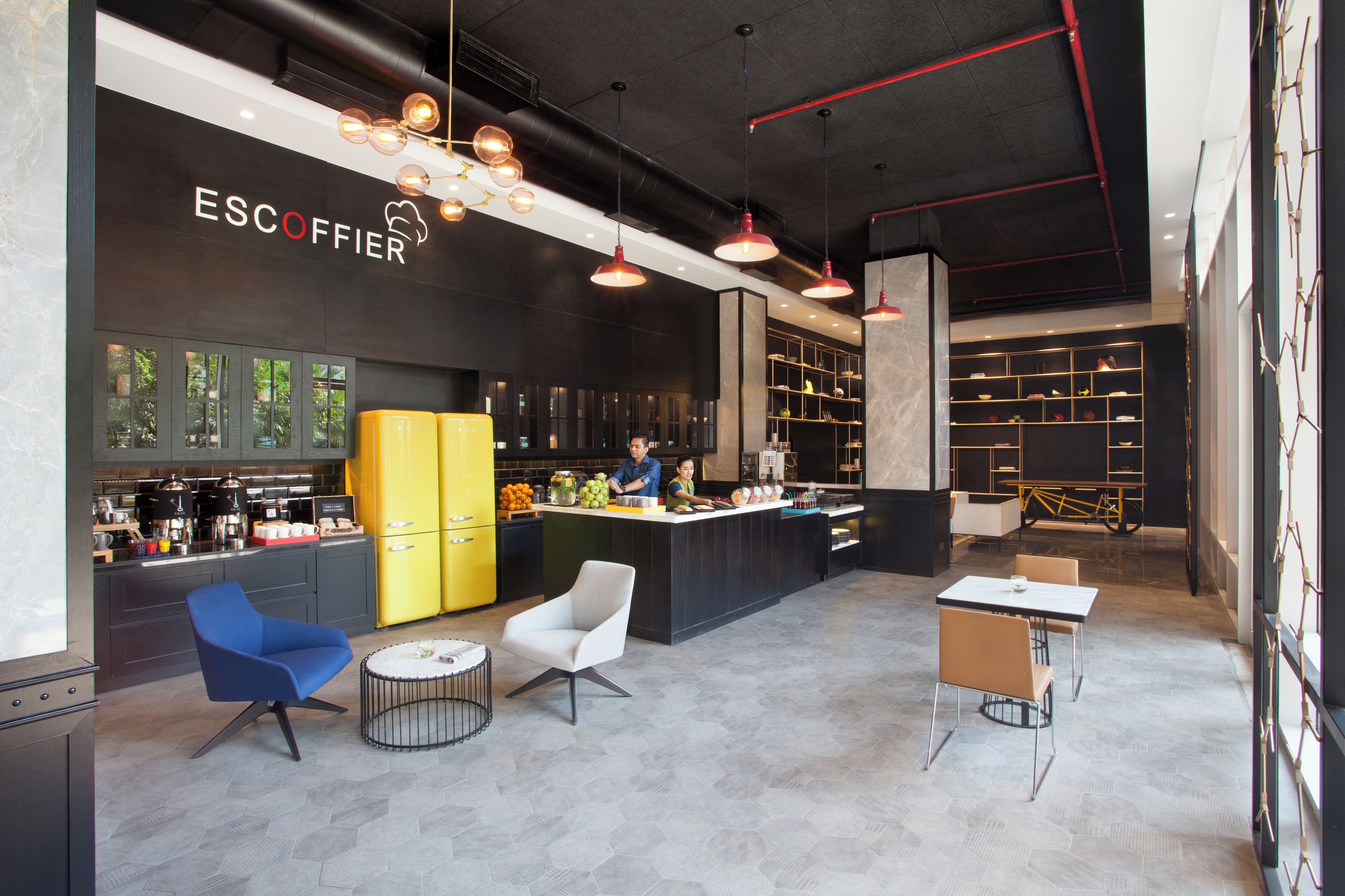 A modern bar area with seating, a counter, and a visible kitchen area.