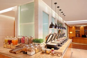 A buffet area with various food items and condiments.