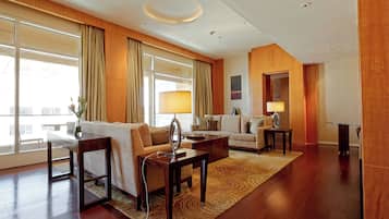 A modern hotel room with a large window, a sofa, a coffee table, and a lamp.