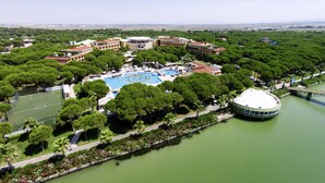 A resort with a central swimming pool, surrounded by lush greenery and a river. - ROBINSON NOBILIS - All Inclusive (Serik)