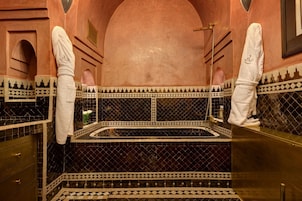 Un bagno con piastrelle a motivi bianchi e neri, una vasca e un appendi asciugamani.