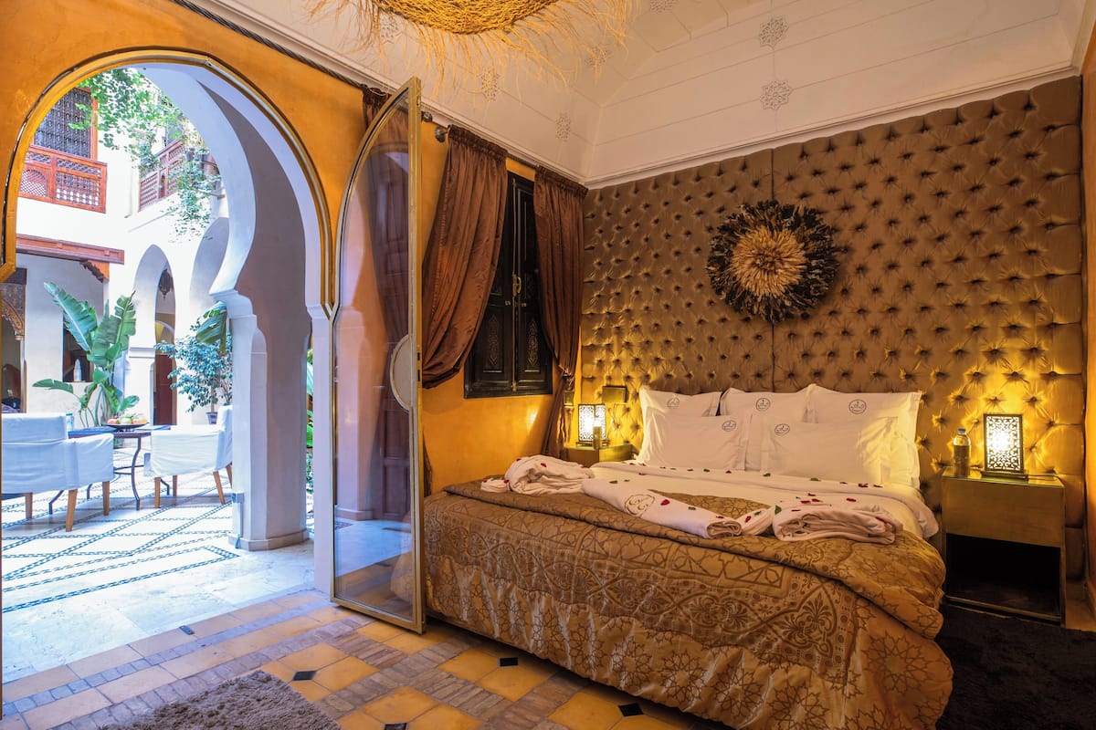 Un dormitorio con una cama grande, vistas al patio y una pared decorativa.