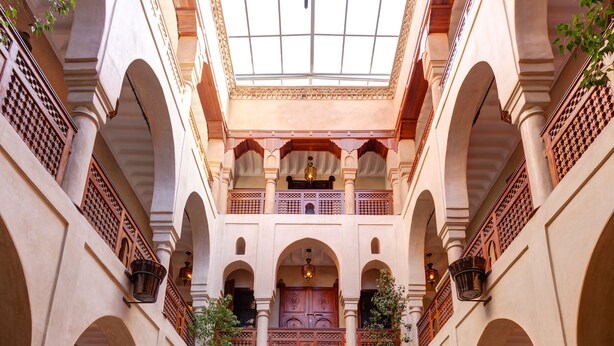 A spacious courtyard with a central pool, arched walkways, and ornate railings. - Riad Wow (Marrakech)