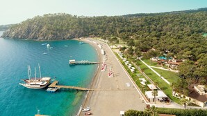 A coastal area with a beach, a pier, and a row of beachside villas. - ROBINSON ÇAMYUVA Adults Only- All Inclusive (Kemer)