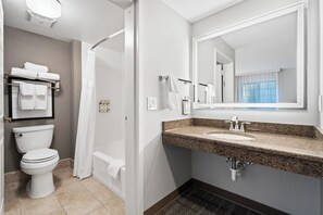 A modern bathroom with a toilet, shower, and sink. - Staybridge Suites North Brunswick by IHG (North Brunswick)