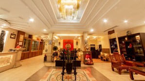 A spacious lobby with a high ceiling, a central chandelier, and a reception desk. - Gold Coast Da Nang Hotel (Da Nang)